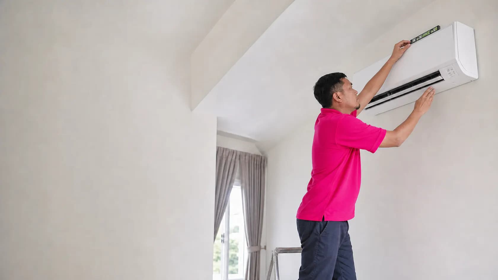 GenPlus technician checking the level of a newly installed air conditioner in Petaling Jaya